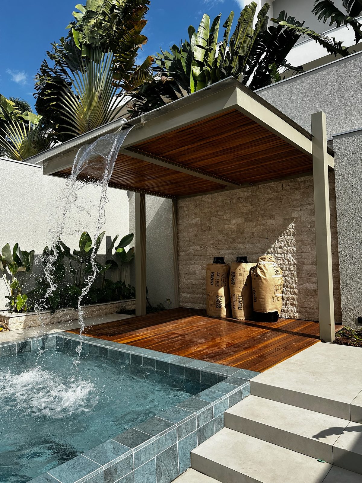 Cobertura metálica com forro de madeira e cascata em área de piscina, executada pela Genesis Steel